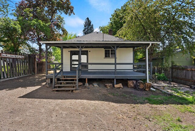 back of property with a fenced backyard, a chimney, and a shingled roof