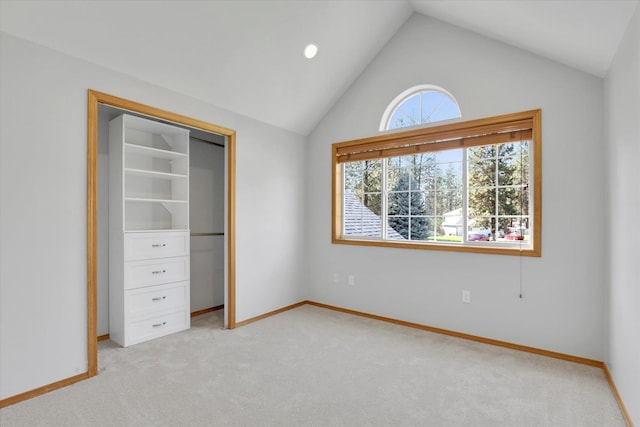 unfurnished bedroom with vaulted ceiling, light carpet, baseboards, and a closet