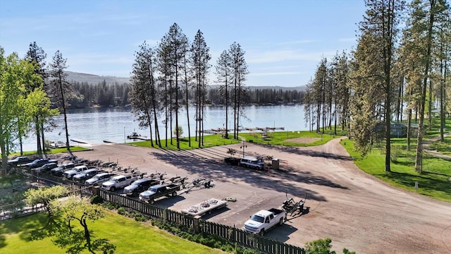 water view with fence and a heavily wooded area
