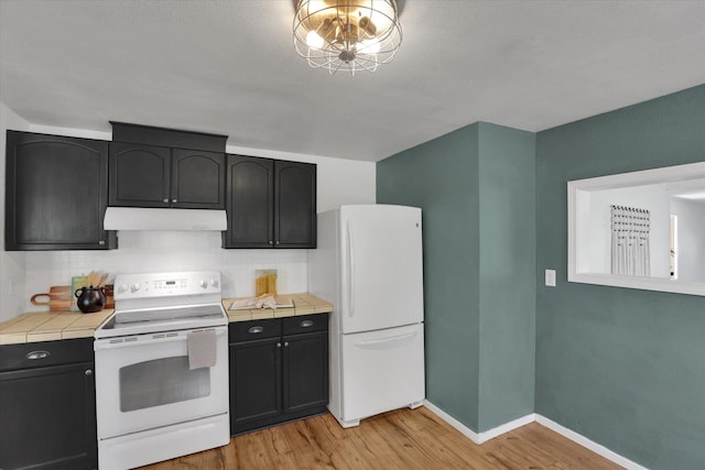 2709 E Sharp Ave, Spokane, WA 99202 - kitchen featuring white appliances, under cabinet range hood, tile countertops, light wood finished floors, and decorative backsplash