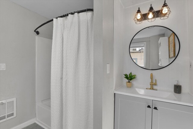 2709 E Sharp Ave, Spokane, WA 99202 - bathroom featuring vanity, baseboards, and shower / bathtub combination with curtain