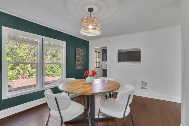 2709 E Sharp Ave, Spokane, WA 99202 - dining space featuring baseboards, wood-type flooring, crown molding, and a chandelier