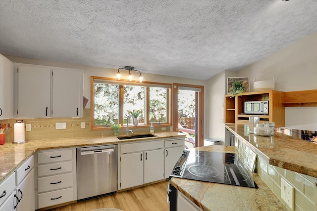 kitchen with dishwasher, a sink, white microwave, light wood finished floors, and white cabinetry