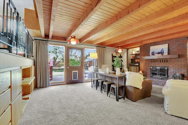 carpeted living area featuring a fireplace, beamed ceiling, and wooden ceiling