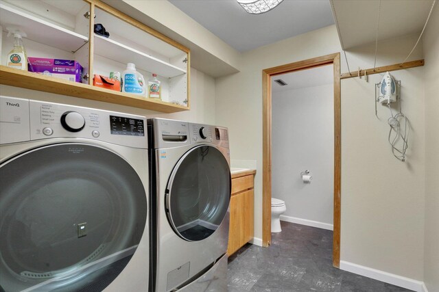 washroom featuring washer and dryer and baseboards