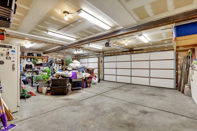 garage with freestanding refrigerator and a garage door opener