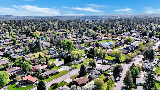 aerial view of property's location featuring a heavily wooded area and nearby suburban area