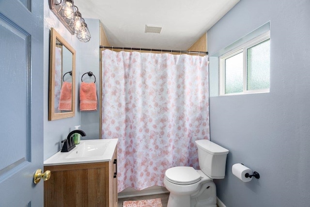 bathroom with toilet, vanity, a shower with curtain, and baseboards