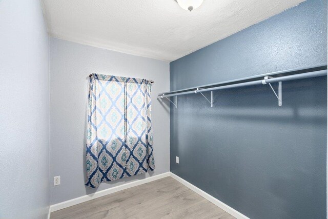 walk in closet with wood finished floors