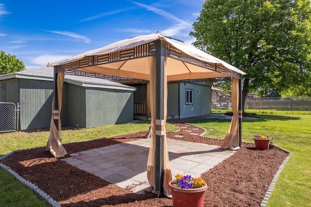 view of patio with a gazebo and an outbuilding