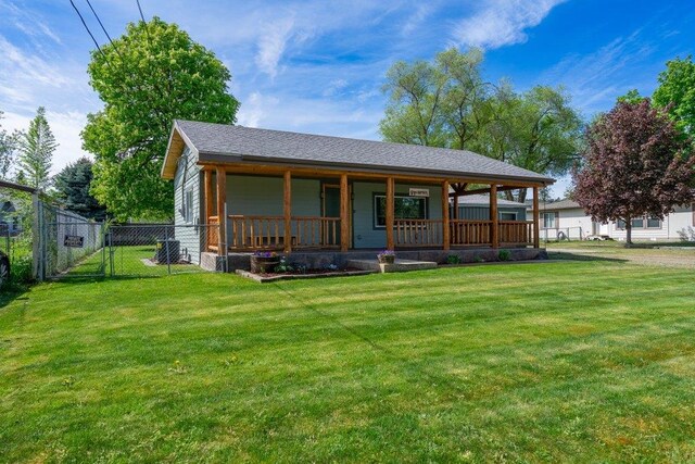 back of property featuring covered porch and a gate