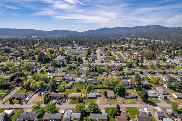 aerial view of property's location featuring a mountainous background and nearby suburban area