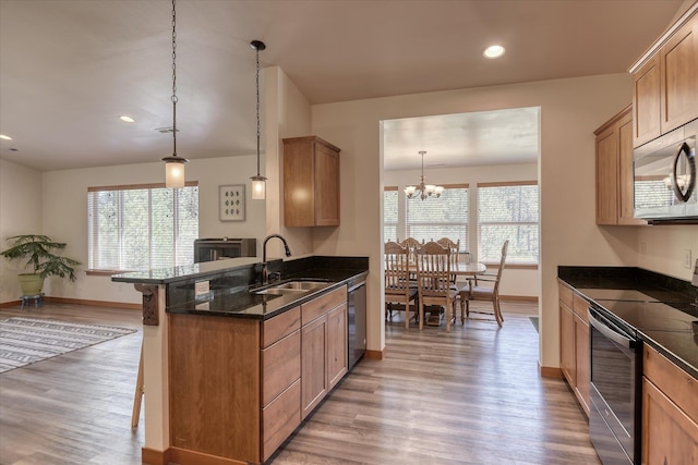 kitchen with a sink, appliances with stainless steel finishes, baseboards, light wood-style flooring, and recessed lighting