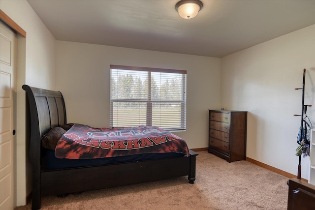 bedroom with light colored carpet and baseboards