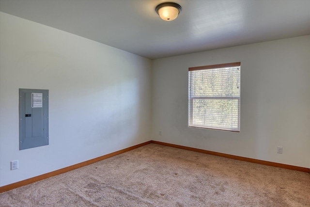 carpeted spare room with electric panel and baseboards