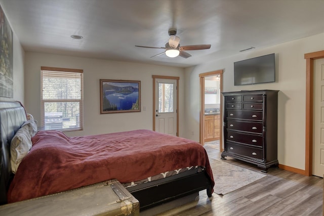 bedroom with multiple windows, wood finished floors, baseboards, and ceiling fan