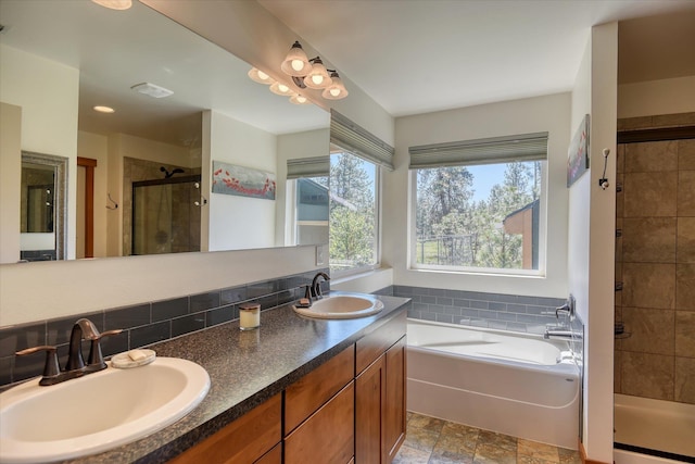 bathroom featuring a stall shower, double vanity, a garden tub, and stone finish floors