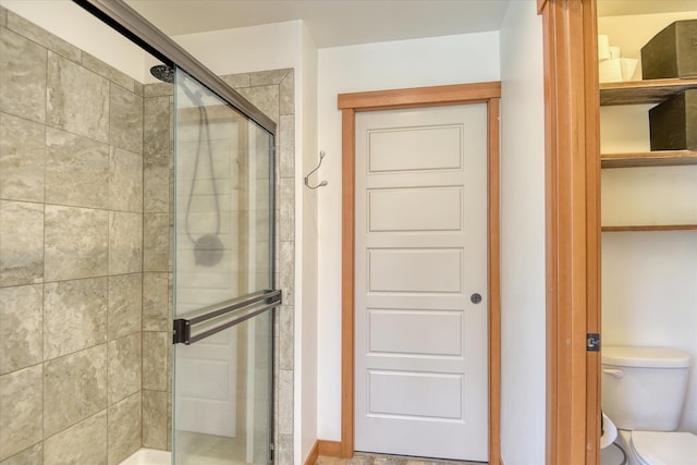 bathroom with a stall shower and toilet