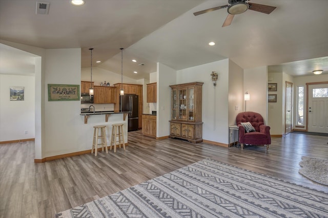 living room featuring lofted ceiling, wood finished floors, baseboards, a ceiling fan, and recessed lighting