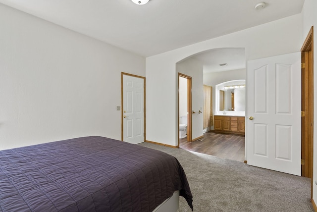 2238 Green Rd, Newport, WA 99156 - carpeted bedroom with arched walkways, connected bathroom, and baseboards