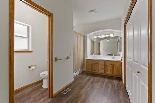 2238 Green Rd, Newport, WA 99156 - bathroom featuring toilet, wood finished floors, double vanity, and baseboards