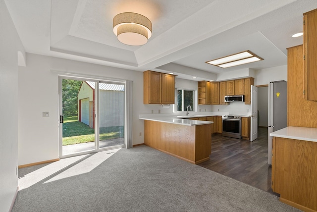 2238 Green Rd, Newport, WA 99156 - kitchen featuring appliances with stainless steel finishes, a peninsula, brown cabinets, open shelves, and dark carpet