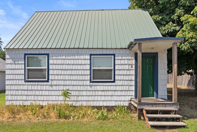 rear view of house featuring metal roof and fence