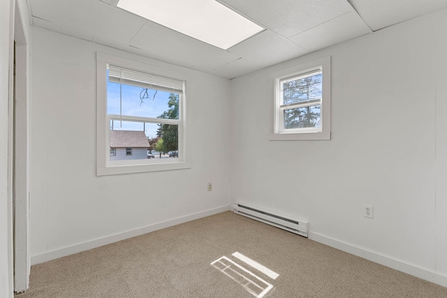 empty room with baseboard heating, carpet floors, and baseboards