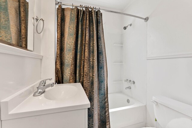 bathroom with toilet, shower / bath combination with curtain, and vanity