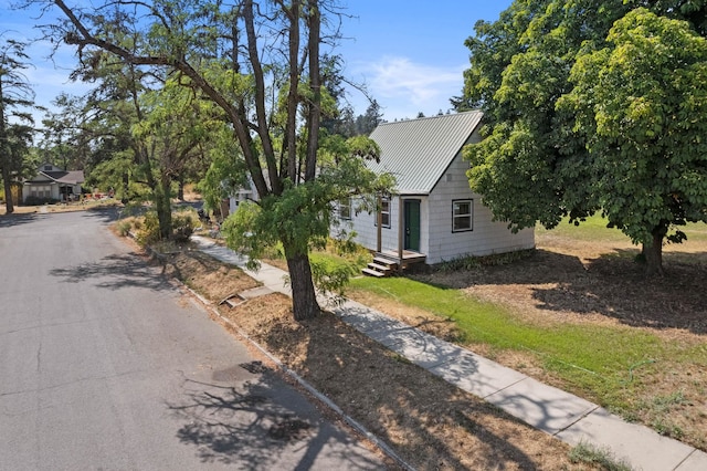 view of property hidden behind natural elements featuring metal roof