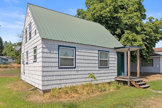 view of front facade featuring a front lawn and metal roof