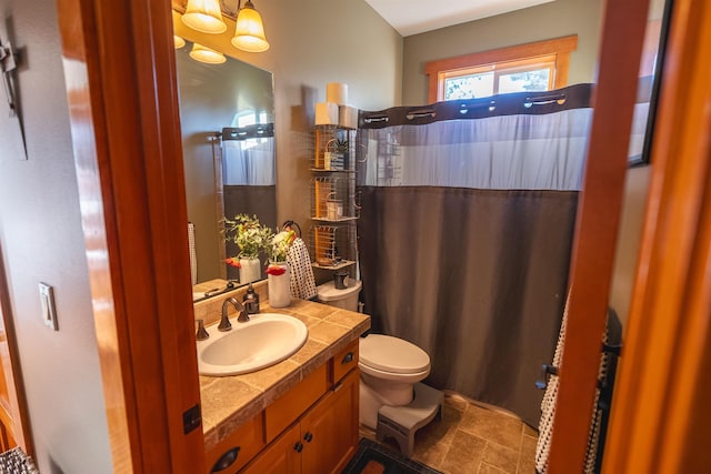 21621 N Lang Ln, Chattaroy, WA 99003 - full bathroom with toilet, vanity, a shower with curtain, stone finish floors, and a chandelier