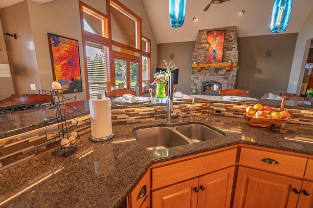 21621 N Lang Ln, Chattaroy, WA 99003 - kitchen with a sink, open floor plan, dark stone counters, a fireplace, and a ceiling fan