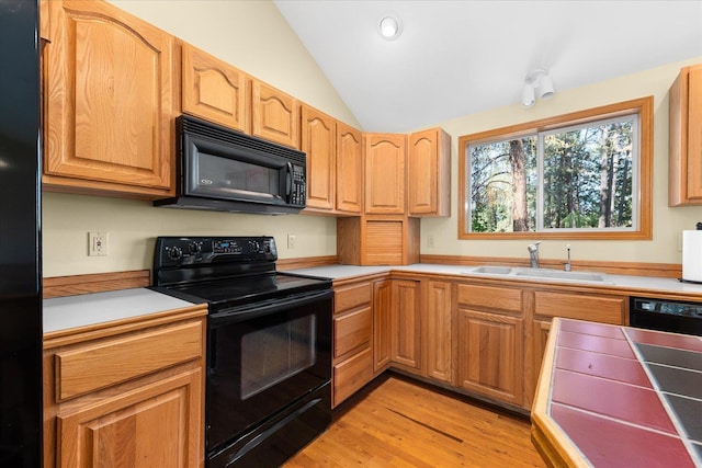 14512 N Dartford Dr, Spokane, WA 99208 - kitchen with black appliances, a sink, lofted ceiling, light wood finished floors, and light countertops
