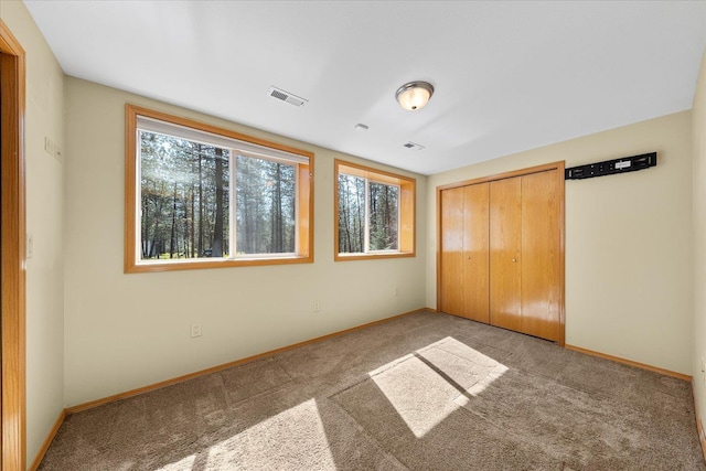 14512 N Dartford Dr, Spokane, WA 99208 - unfurnished bedroom featuring multiple windows, carpet flooring, baseboards, and a closet