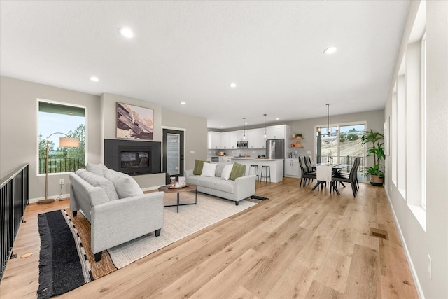4243 W Tolliver Ct, Spokane, WA 99208 - living area featuring light wood-style floors, recessed lighting, baseboards, and a glass covered fireplace