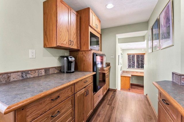 15918 E Cameron Ct, Spokane Valley, WA 99037 - kitchen with oven, dark wood-type flooring, black microwave, brown cabinets, and a textured ceiling