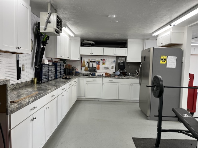 15918 E Cameron Ct, Spokane Valley, WA 99037 - kitchen featuring freestanding refrigerator, a textured ceiling, white cabinets, backsplash, and dark stone countertops