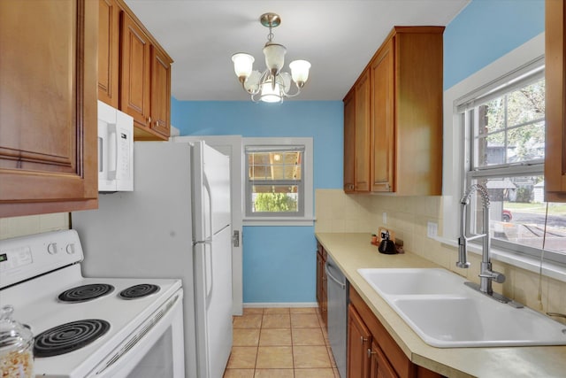 1308 W 11th Ave, Spokane, WA 99204 - kitchen with white appliances, a sink, a chandelier, light countertops, and brown cabinets