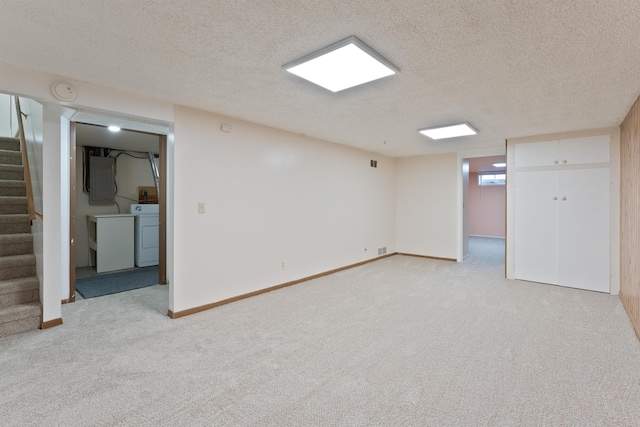 below grade area with stairway, light carpet, washer and dryer, a textured ceiling, and electric panel