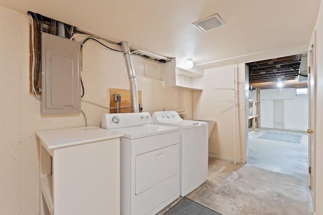 laundry area with electric panel and separate washer and dryer