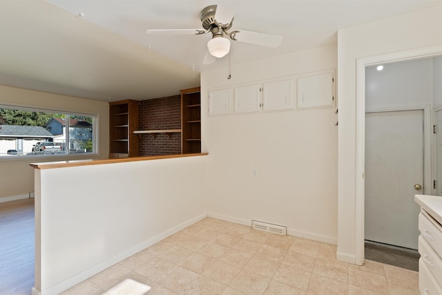 kitchen featuring a ceiling fan, white cabinetry, baseboards, a peninsula, and light countertops