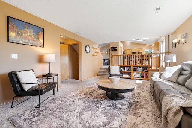 living area with carpet floors, stairs, and vaulted ceiling