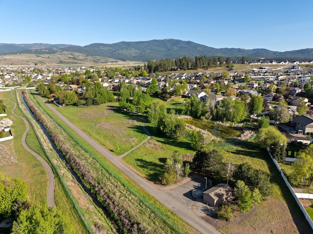 aerial view of property's location featuring a mountain backdrop and nearby suburban area