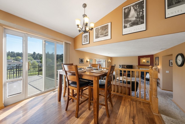 dining room with a chandelier, wood finished floors, and high vaulted ceiling