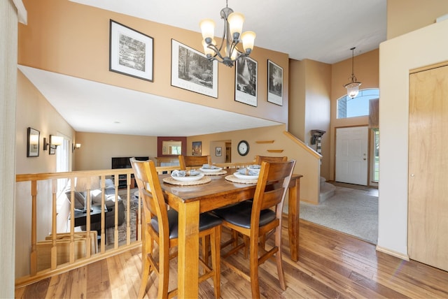dining room featuring hardwood / wood-style floors, a chandelier, and a high ceiling