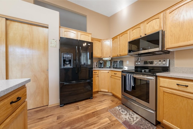 kitchen featuring stainless steel appliances, light brown cabinets, light wood-type flooring, and light countertops