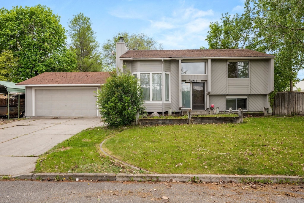 view of front facade with a chimney, concrete driveway, and a garage