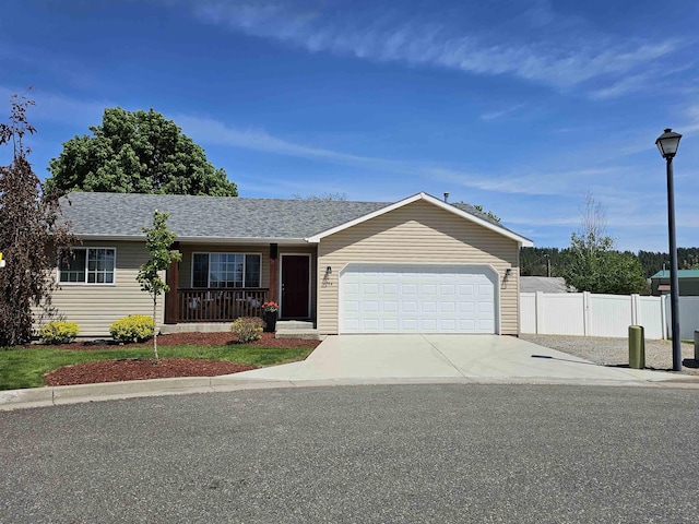 ranch-style home featuring fence, a garage, driveway, and roof with shingles