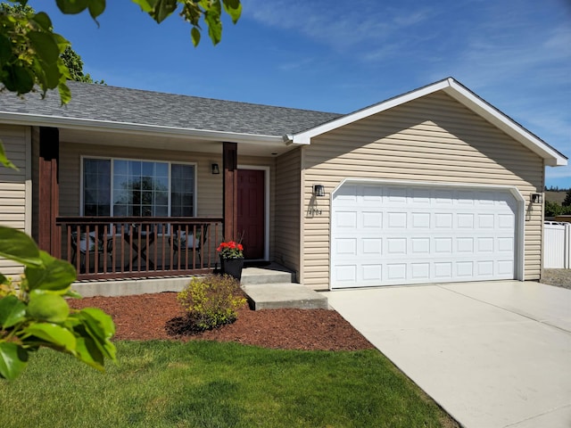 ranch-style house featuring covered porch, a garage, driveway, and a shingled roof